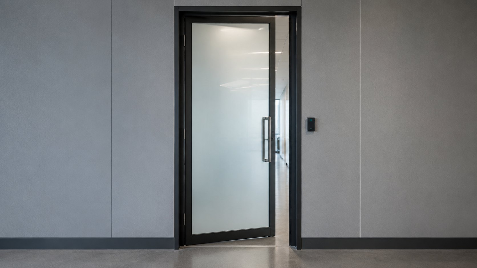 A glass office door standing slightly ajar beside a card reader in a clean corridor